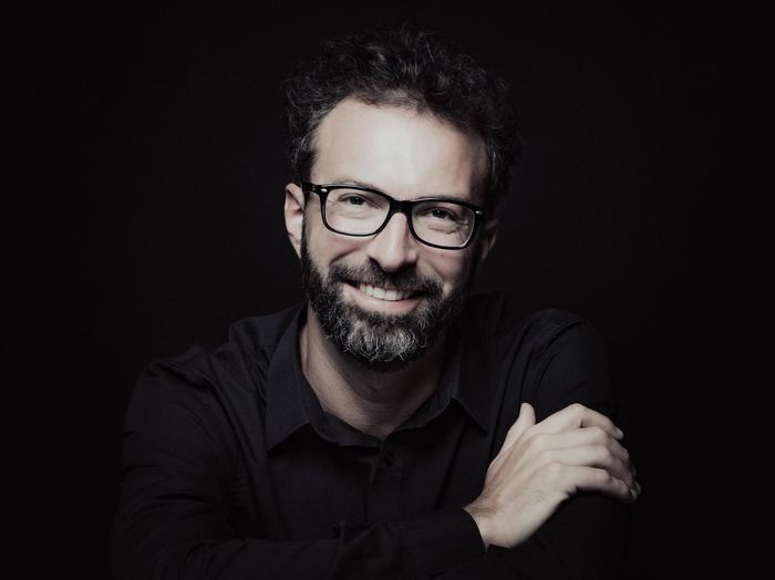Simon Zaoui, sourire, chemise noire sur fond noir